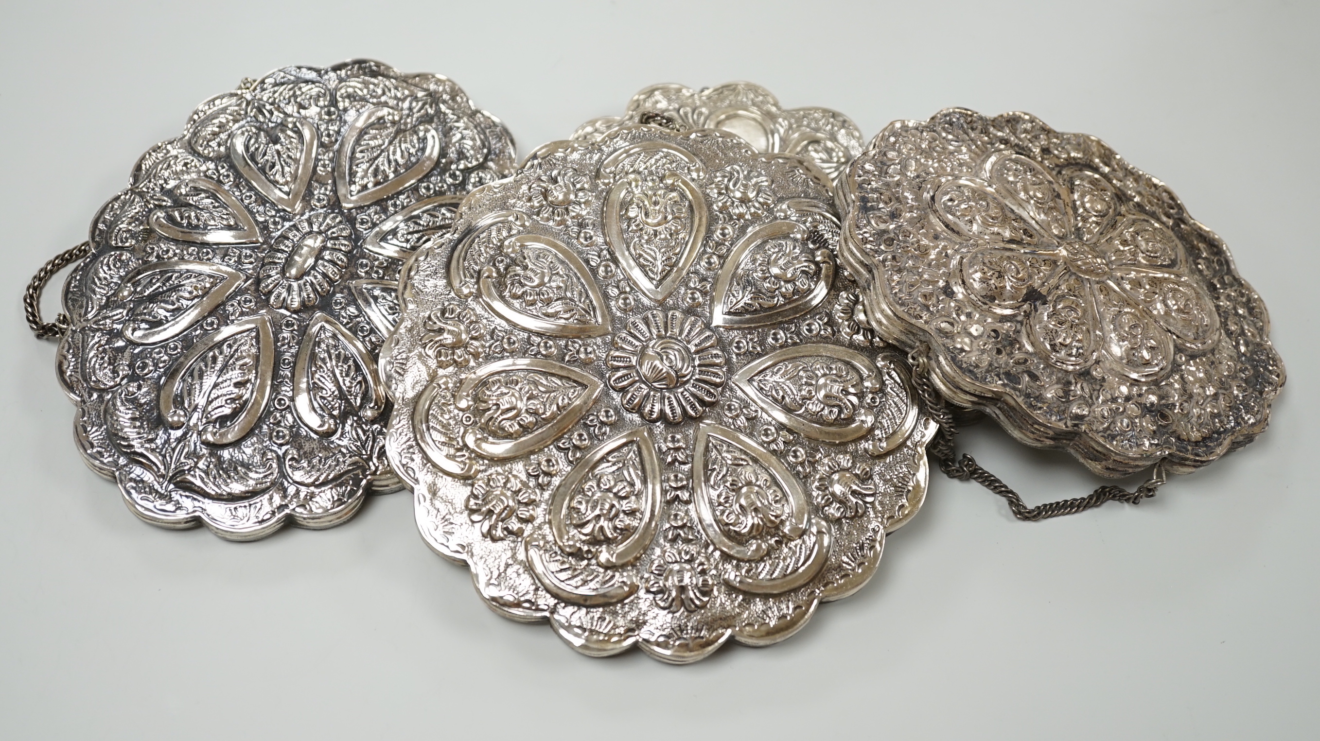 Seven assorted 20th century Persian repousse white metal mounted shaped oval or round mirrors, largest 21cm.